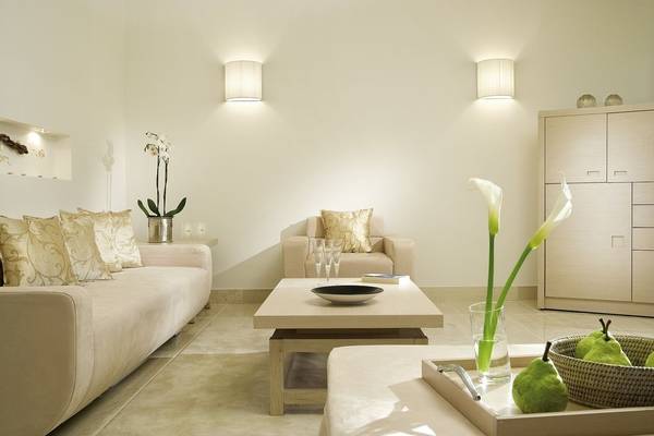 Wohnbereich im Sani Club Hotel mit beigefarbener Couch, Tisch, Kissen und Blumenvase