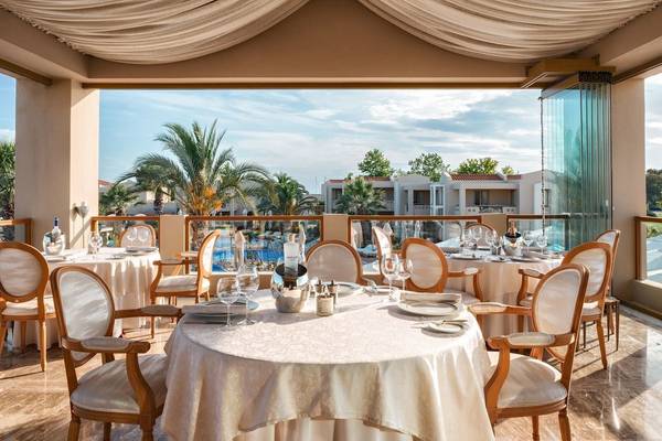 Restaurant im Sani Club mit terrasse und ausblick auf einen pool und palmen