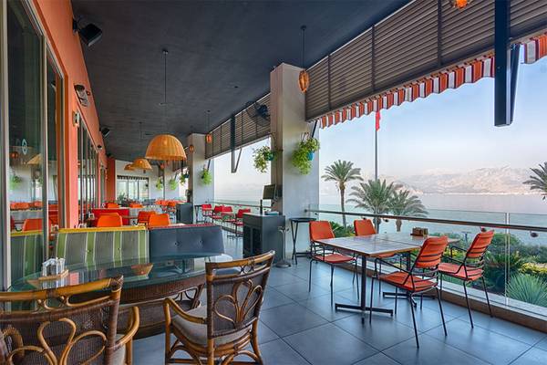 Terrasse des Akra Hotels mit Blick auf das Meer und Berge.