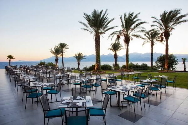 Außenterrasse des Akra Hotels mit Blick auf das Meer und die Berge