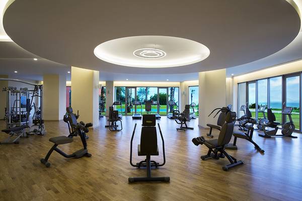 Fitnesscenter im Akra Hotel mit Blick auf das Meer und Swimmingpool