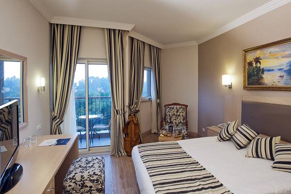 Innenansicht eines Hotelzimmers im Crystal Tat Beach Golf Resort & Spa mit Bett, Balkon und Aussicht.