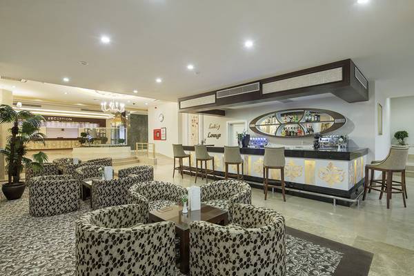 Lobby-Bar im Crystal Tat Beach Golf Resort & Spa mit geschwungenen Möbeln und einer Theke.