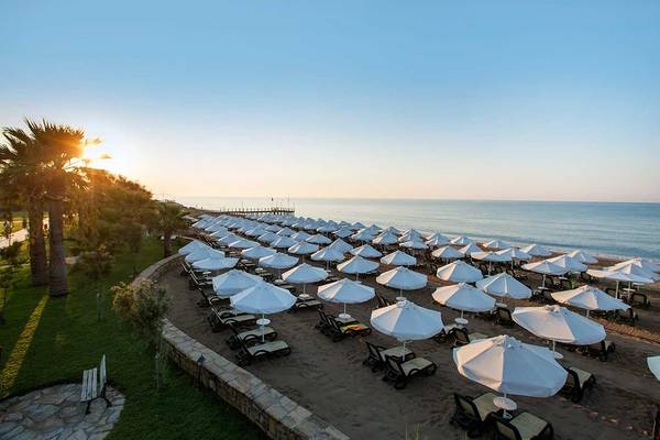 Crystal Tat Beach Golf Resort & Spa Strand mit vielen Sonnenschirmen und Liegen