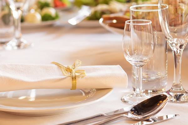 Ein gedeckter Tisch im Crystal Tat Beach Golf Resort & Spa mit Gläsern, Besteck und einem Teller mit Serviette.