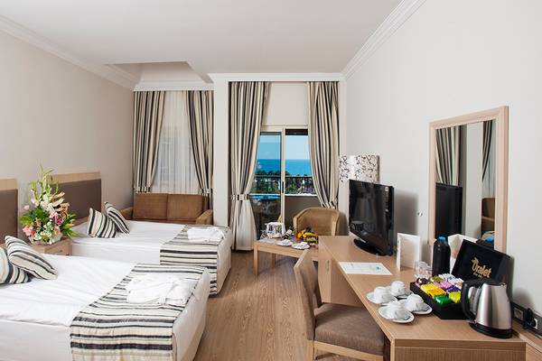 Innenansicht eines Hotelzimmers im Crystal Tat Beach Golf Resort & Spa mit zwei Betten, einem Schreibtisch und einem Ausblick auf das Meer.