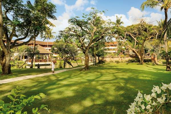 Gartenansicht des Nusa Dua Beach Hotel & Spa mit einem Gehweg und Bäumen