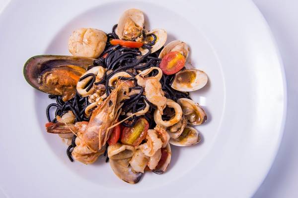 Gerichteteller Teller mit schwarzen Spaghetti, Garnelen, Tintenfisch und Muscheln auf dem Dusit Thani Laguna Phuket
