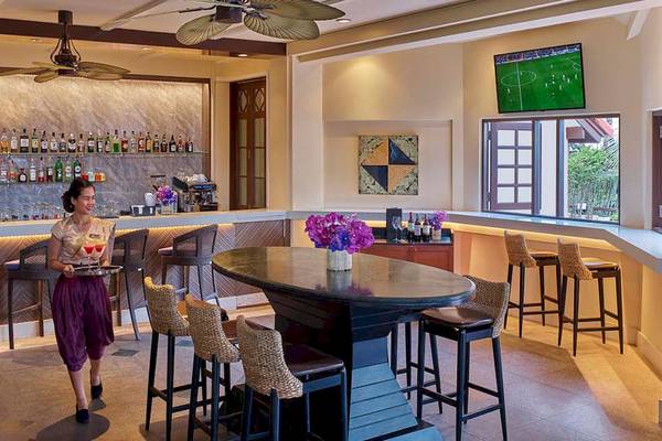 Dame serviert Getraenke am Barbereich des Dusit Thani Laguna Phuket