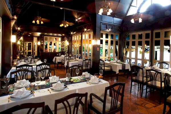 Innenansicht des Restaurants des Dusit Thani Laguna Phuket mit gedeckten Tischen und Stühlen.