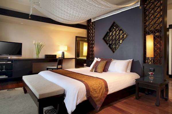 Schlafzimmer im Dusit Thani Laguna Phuket Hotel mit einem Bett, Schreibtisch, Fernseher und Dekor
