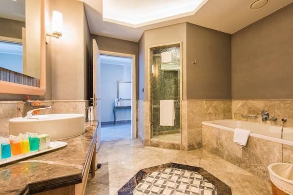 Badezimmer im Xanadu Island Bodrum Hotel mit Marmorboden, Badewanne und Dusche