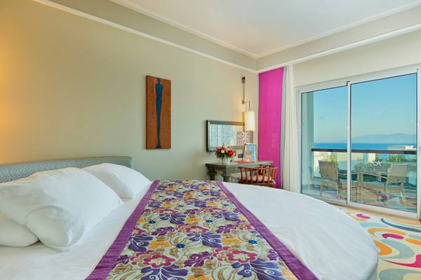 Schlafzimmer im Xanadu Island Bodrum Hotel mit Meerblick, einem großen Bett, und einem Balkon.