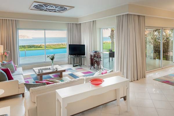 Wohnzimmer im Xanadu Island Bodrum Hotel mit Blick auf das Meer und einen Swimmingpool.