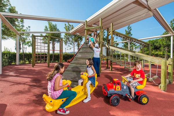 Kinder spielen auf dem Spielplatz im Xanadu Island Bodrum Hotel, mit Rutsche und Klettergerüst.
