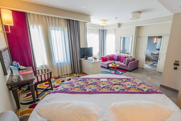 Hotelzimmer im Xanadu Island Bodrum mit Bett, Sofa, Fernseher und Tisch.