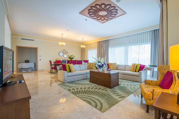 Wohnzimmer im Xanadu Island Bodrum Hotel mit Sofas, Teppich und Deko-Lampe.
