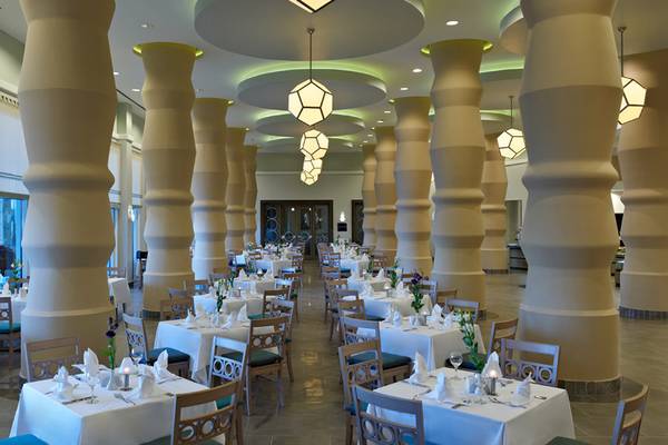 Innenansicht des Restaurants im Xanadu Island Bodrum Hotel mit eleganten Tischeinstellungen und hohen Säulen.