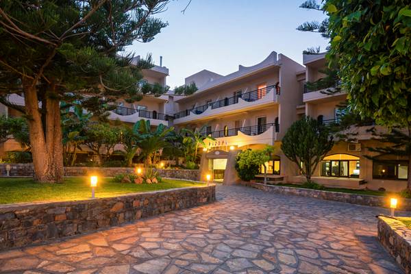 Der Eingangsbereich des Themis Beach Hotels bei Nacht mit Steinweg und Beleuchtung.