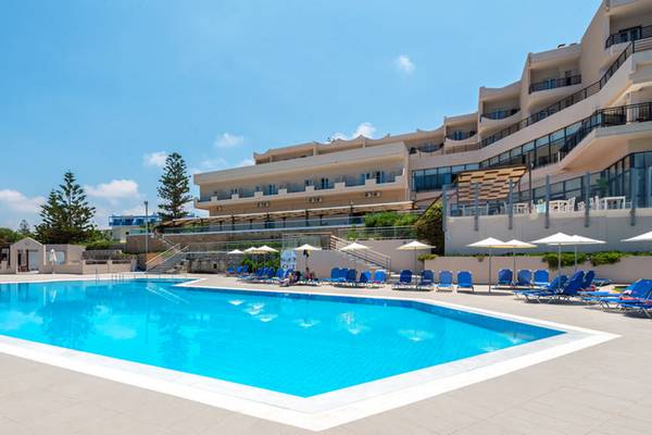 Außenpool des Themis Beach Hotels mit blauen Liegestühlen und Sonnenschirmen