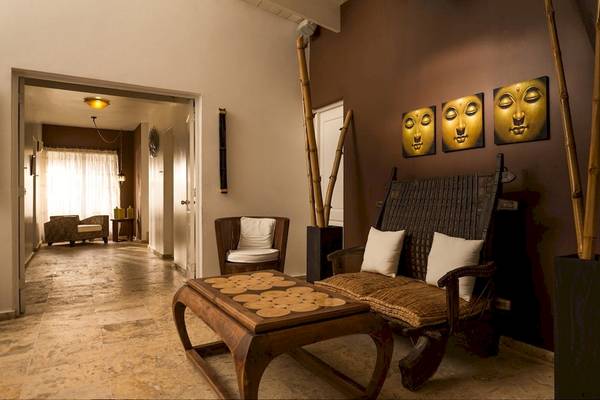 Innenbereich des BlueBay Villas Doradas mit Lounge-Bereich, Möbeln und Buddha-Bildern.