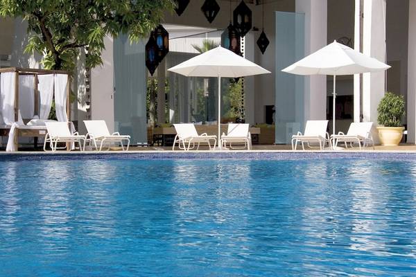 Poolbereich des BlueBay Villas Doradas Hotels mit weißen Sonnenschirmen und Liegen.