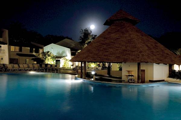 Der Swimmingpool des BlueBay Villas Doradas Hotels bei Nacht mit Mond und Beleuchtung.