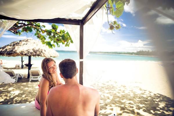 Paar im BlueBay Villas Doradas auf der Strandbank mit Blick auf das Meer