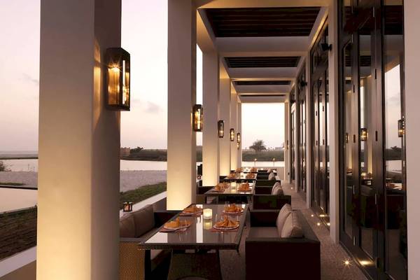 Innenansicht des Restaurants im Al Baleed Resort Salalah by Anantara mit Blick auf den See