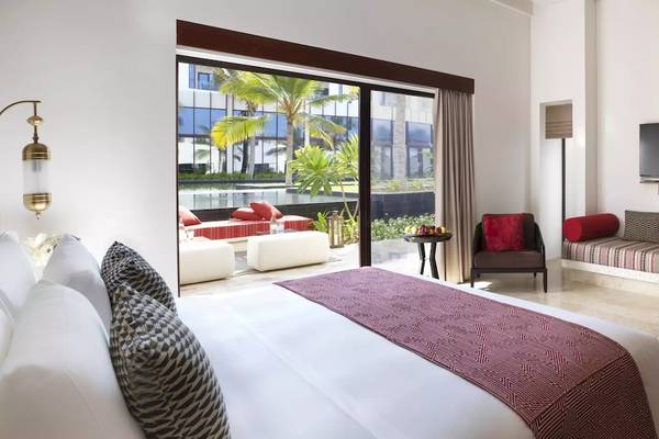 Innenansicht einer Suite im Al Baleed Resort Salalah von Anantara mit Bett, Möbeln und Aussicht