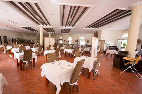 Innenansicht des Restaurants im Green Palm Hotel mit gedeckten Tischen und Stühlen.