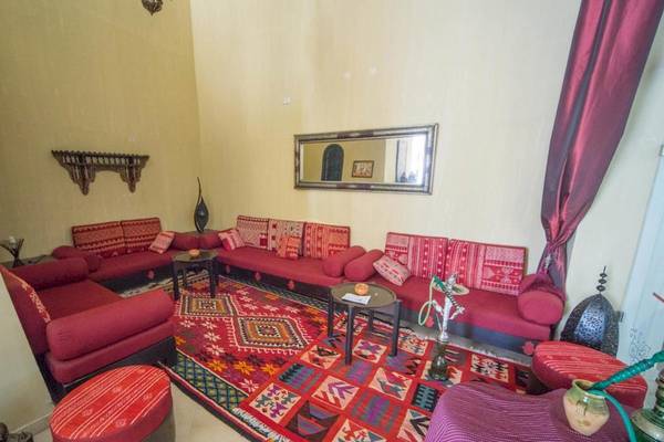 Wohnzimmer mit roten Sofas, einem Teppich und einer dekorativen Wand