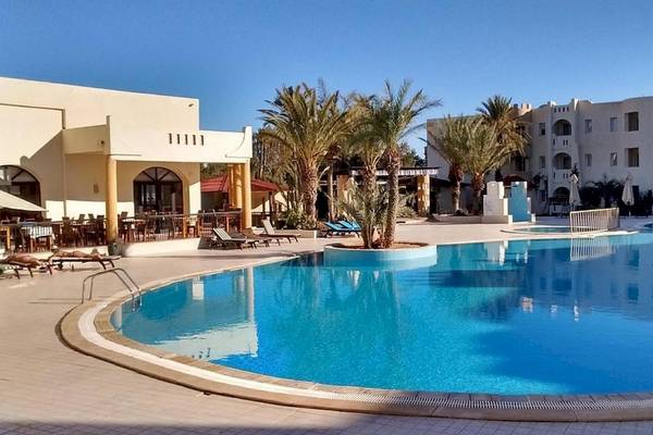 Außenpool des Green Palm Hotels mit Palmen und Sonnenliegen.