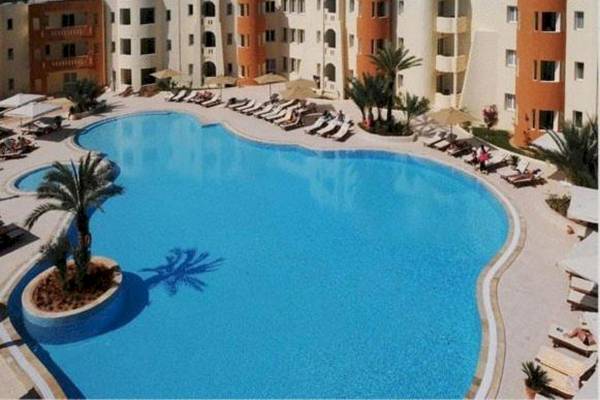 Außenpool des Green Palm Hotels mit vielen Liegen und Sonnenschirmen.