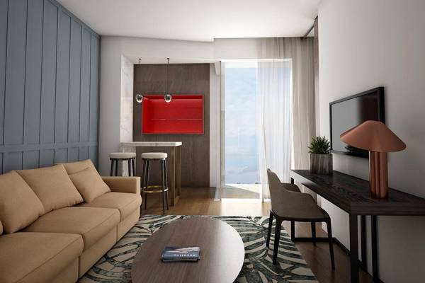Innenansicht des Wohnzimmers im NissiBlu Beach Resort mit Couch, Tisch, Fernseher und Blick auf den Ozean.