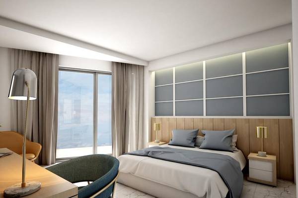 Innenansicht eines Hotelzimmers im NissiBlu Beach Resort mit einem Bett, Schreibtisch und Fenster.