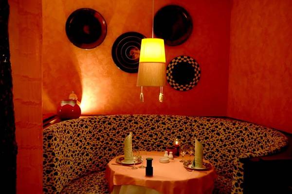 Innenbereich des Calista Luxury Resorts mit einem Tisch, einer Bank und orangefarbenen Wänden.