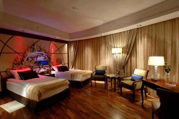 Doppelzimmer im Calista Luxury Resort mit zwei Betten, Sesseln und Schreibtischen.