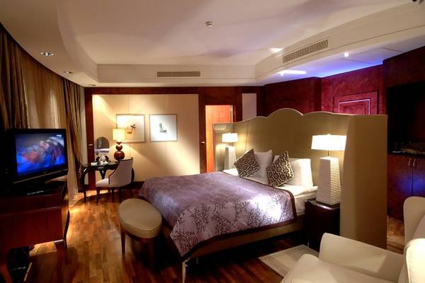 Schlafzimmer im Calista Luxury Resort mit großem Bett, Fernseher und Möbeln.