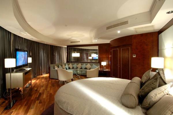 Schlafzimmer im Calista Luxury Resort mit Rundbett, Fernseher, Sofa und Lampen.