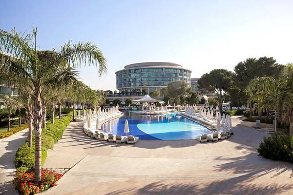 Außenbereich des Calista Luxury Resort mit Swimmingpool, Liegestühlen und Palmen