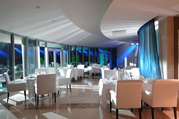 Innenbereich des Calista Luxury Resorts mit mehreren weißen Tischen und Stühlen.