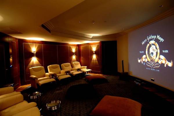 Kinoraum im Calista Luxury Resort mit gepolsterten Sesseln und einer großen Leinwand.