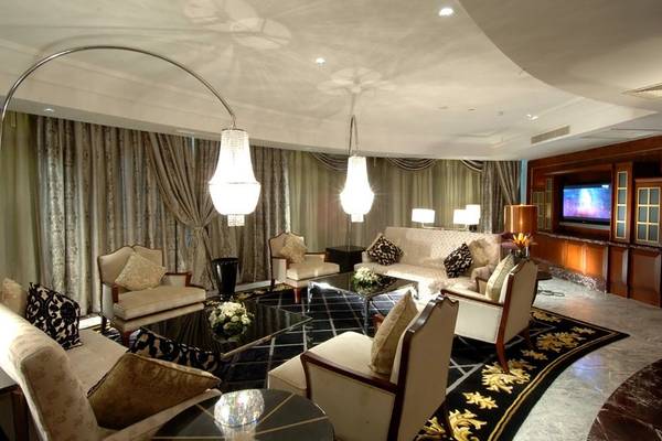 Wohnbereich im Calista Luxury Resort mit eleganten Möbeln, Kristalllampen und einem Fernseher.