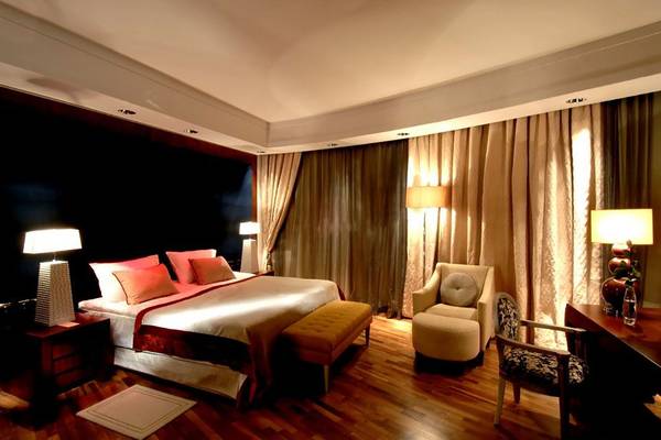 Schlafzimmer im Calista Luxury Resort mit Bett, Sesseln und Schreibtisch