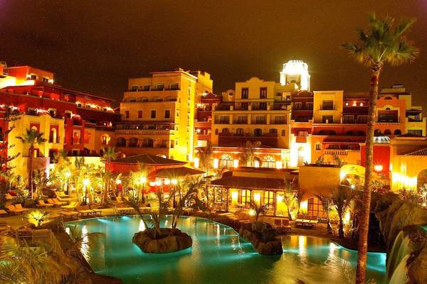 Villa Cortes Hotelanlage bei Nacht, mit beleuchteten Gebäuden, Swimmingpool und Palmen