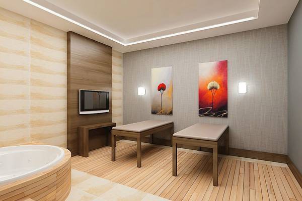 Innenansicht des Behandlungsraums im Adalya Ocean Deluxe Hotel mit Whirlpool, Massagetischen und Kunstwerken an der Wand.