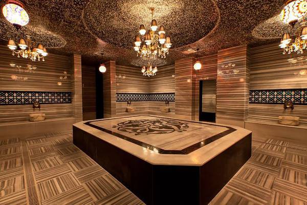 Innenbereich der Sauna im Adalya Ocean Deluxe Hotel mit Marmorboden und dekorativen Kronleuchtern.