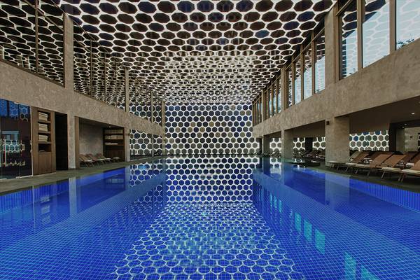 Innenpool im Maxx Royal Kemer Resort mit blauer Fliesendecke und geometrischem Muster.