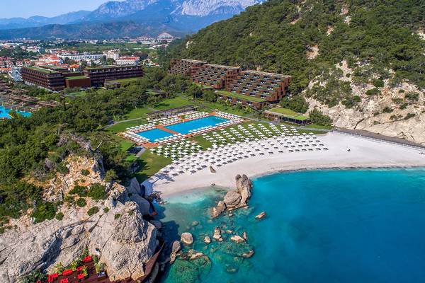 Luftaufnahme des Maxx Royal Kemer Resort mit Swimmingpool, weißen Liegen und türkisfarbenem Meer
